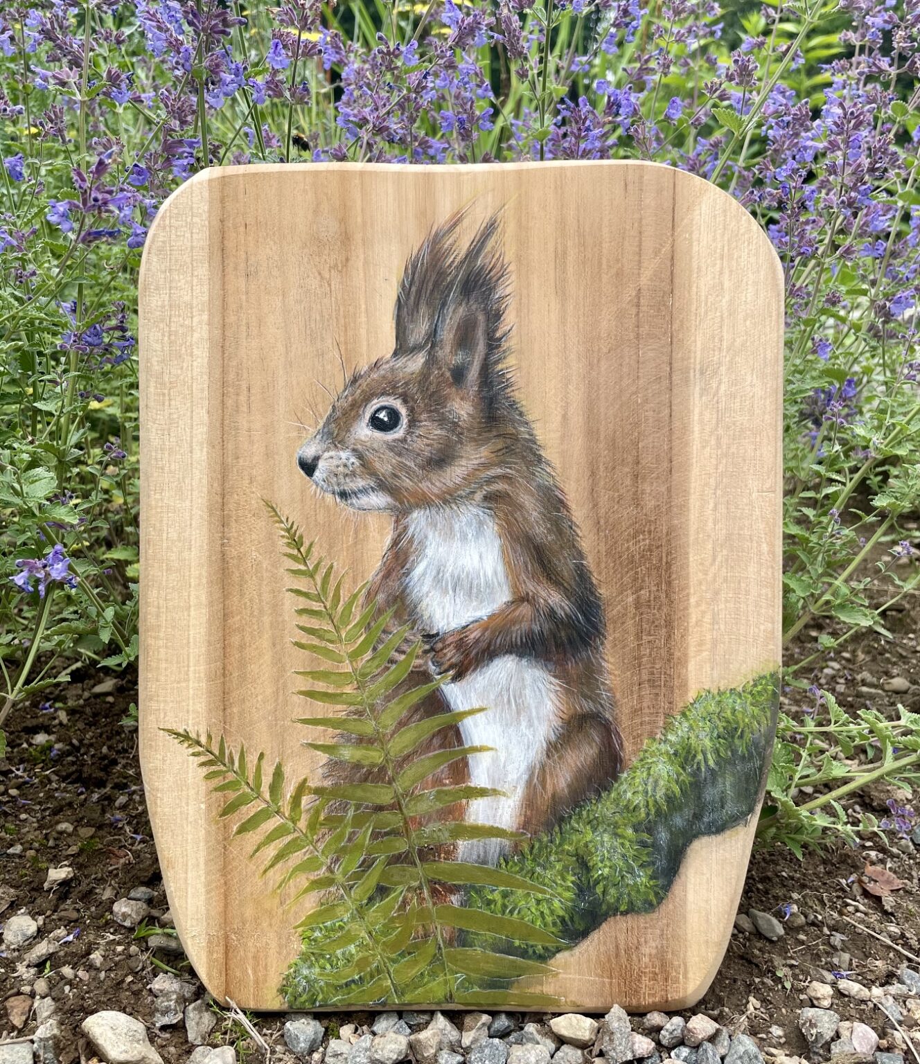 Handmålad ekorre på en bit teak.